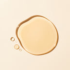 A glossy, translucent droplet of golden-beige cosmetic liquid