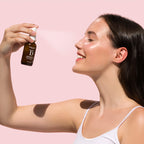 A woman with dark hair and a white tank top sprays botanical d facial mist