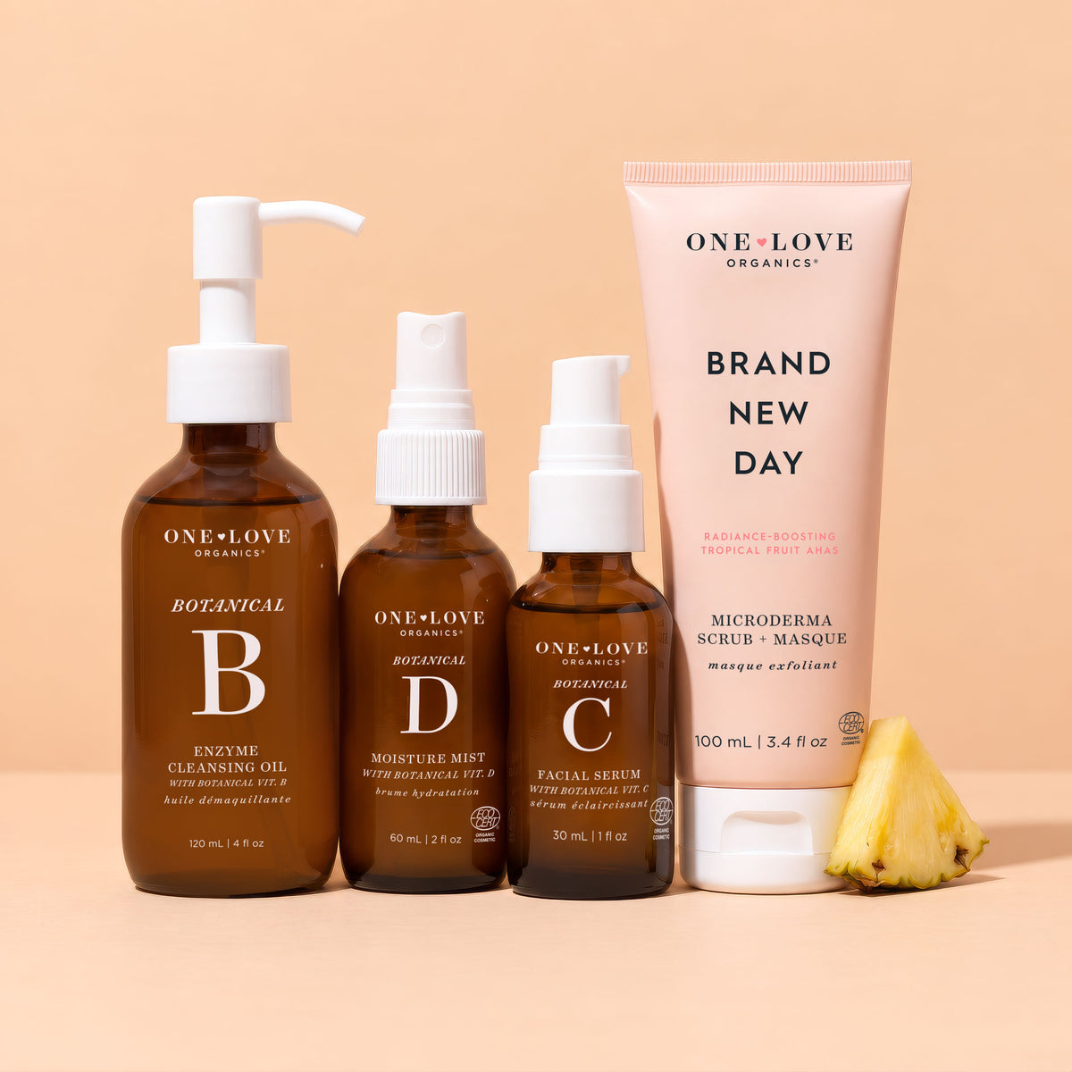 A set of One Love Organics skincare products arranged on a warm peach background