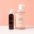 Two bottles of 'One Love Beauty' foaming cleanser on a peach background