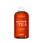 A 240 mL amber-brown bottle of One Love Organics Gardenia + Tea Antioxidant Body 