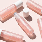 Several pink roll-on eye serum bottles