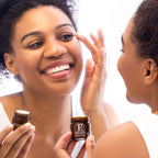 A smiling woman applies botanical E eye cream