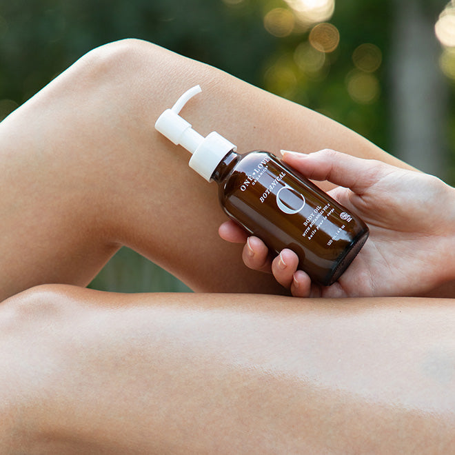A person holding a bottle of botanical C body oil 