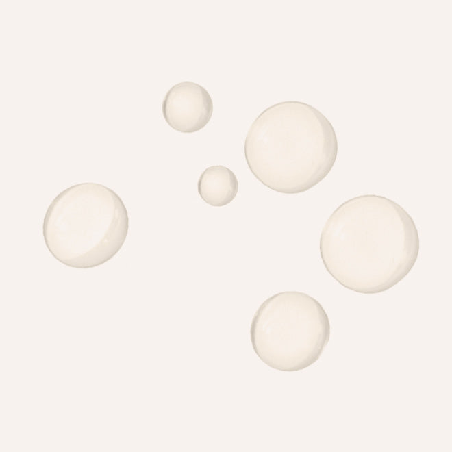 Five translucent, frosted glass-like spheres in varying sizes scattered on a solid off-white background.