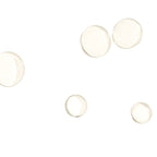 Five clear, dome-shaped cabochon gemstones in various sizes scattered on a solid white background.